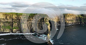 Cliffs of Moher shrouded in low clouds on a sunset in 4k