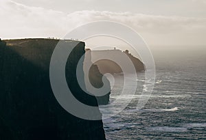 Cliffs of Moher at Sunset with Silhouettes of People on the Edge
