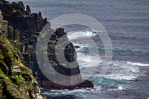 Cliffs with moss by the sea and seabirds in the coastal