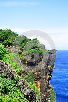 Cliffs near Uluwatu Temple on Bali, Indonesia. Beautiful blossom Uluwatu Temple on Bali, Indonesia.