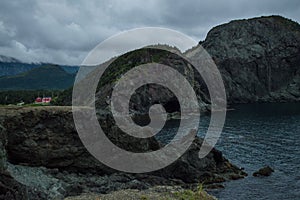 Cliffs and Red House along a Rugged Coastline at Lark Harbor in Newfoundland