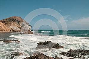 Cliffs, rocks and waves on the coast of the Mediterranean Sea on a clear day. photo