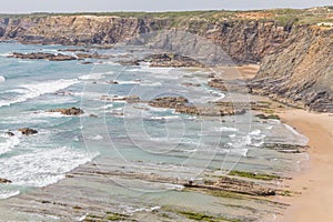 Cliffs, rocks and waves in Zambujeira do Mar beach photo