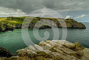 Clifftop view of Bossiney Cove at high tide.