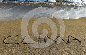 clima written in sand at the seaside