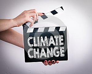 Climate change. Female hands holding movie clapper