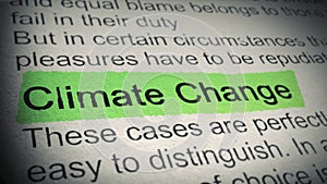 Climate Change. Highlighter pen marks word in an open book. Closeup. Thumbing pages and promoting text with marker.