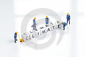 Climate change, recycle or environment and ecology concept, miniature people worker using tools building the word Climate on clean