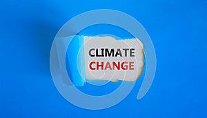 Climate change symbol. Words `climate change` appearing behind torn blue paper. Beautiful blue background, copy space. Business,