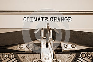 Climate change symbol. Words `climate change` typed on retro typewriter. Beautiful white background, copy space. Sepia effect.