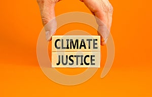 Climate justice symbol. Concept words Climate justice on beautiful wooden blocks. Beautiful orange table orange background.