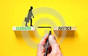 Climate justice symbol. Concept words Climate justice on beautiful wooden blocks. Beautiful yellow table yellow background.