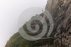 A climb in the fog in the Alpstein area of the Swiss Alps on the steep ridge of the majestic Schaefler peak in Appenzell