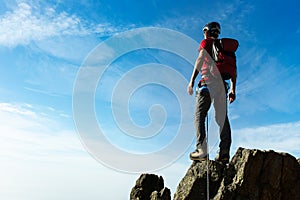 Climber arrive on the summit of a mountain peak. Concepts: victo