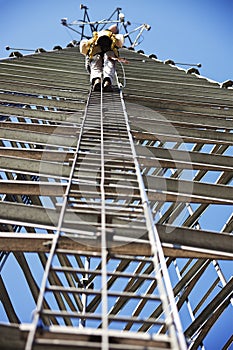 Climber ascending cell phone tower