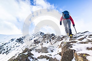 A climber ascending a snow covered ridge