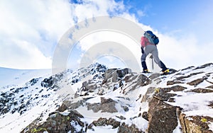 A climber ascending a snow covered ridge