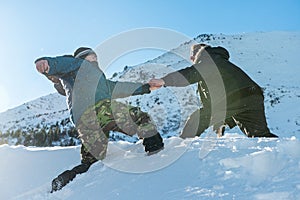 Climber assists another climber on the slope of snowy mountains