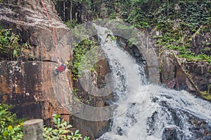 Climber in the background of beautiful cascading Datanla waterfall In the mountain town Dalat, Vietnam