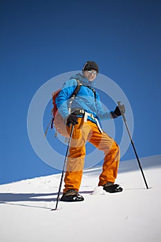 Climber with a backpack climbs the snow.