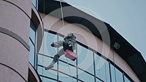 Climber with cleaning equipment outside the building