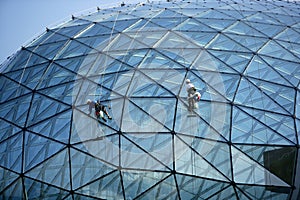 Climber cleaning mirror glass dome building