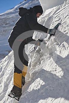 Climber climb the mountain through snow blown away by the strong wind.