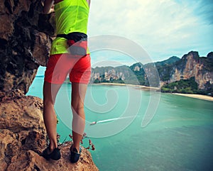 Climber climbing at seaside cliff