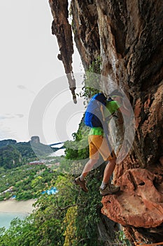 Climber climbing at seaside cliff