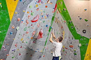 Climber explores and develops a route on a climbing wall in the boulder hall