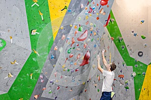 Climber explores and develops a route on a climbing wall in the boulder hall