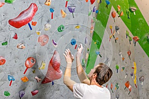 Climber explores and develops a route on a climbing wall in the boulder hall