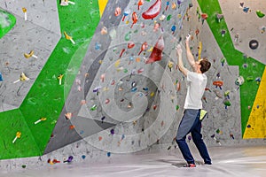 Climber explores and develops a route on a climbing wall in the boulder hall
