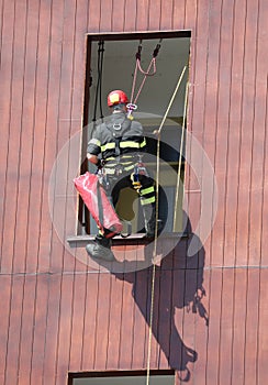 Climber firefighter go in the house by window