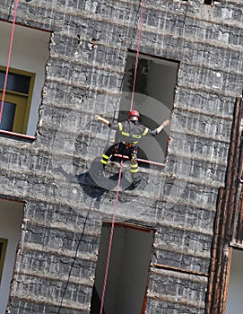 climber of firefighters rappelling the wall during the fire drill