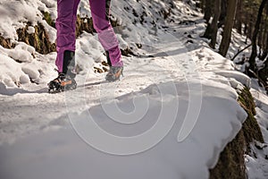 Climber on a frozen waterfall. Crampons close-up on his feet ice climber