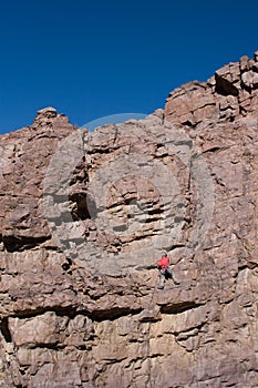 Climber halfway up cliff