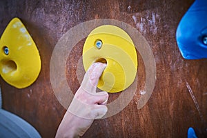 Climber hand on the bouldering climbing wall round grip