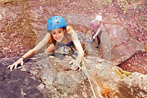 Climber in helmet reaching top of the mountains