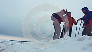 Climber helping teammate climb, the man with the backpack reached out a helping hand to his friend. Three climbers on a