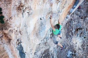 Climber holding on handhold while climbing cliff