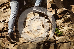 The climber holds his hand over the ledge of the cliff