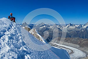 Climber on a knife edge snow mountain ridge