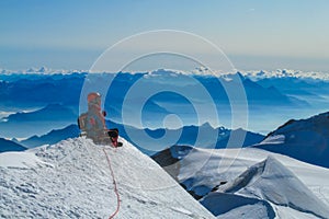 Climber on a knife edge snow mountain ridge