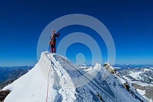 Climber on a knife edge snow mountain ridge