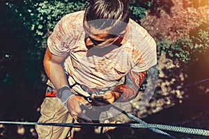 Climber Man Hanging On A Rock On A Rope And Looks Somewhere On The Wall. Extreme Lifestyle Outdoor Activity Concept