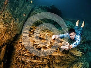 Climber man holds cliff underwater