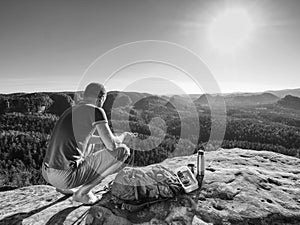 Climber man sit on rock, prepare for eating snack during rest photo