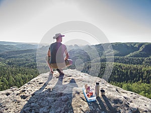 Climber man sit on rock, prepare for eating snack during rest photo