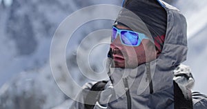 Climber mountaineer man portrait on snowy mount top in sunny day.Mountaineering ski activity. Skier people winter snow